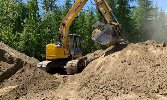 A winco works excavator working on a construction site in the forest